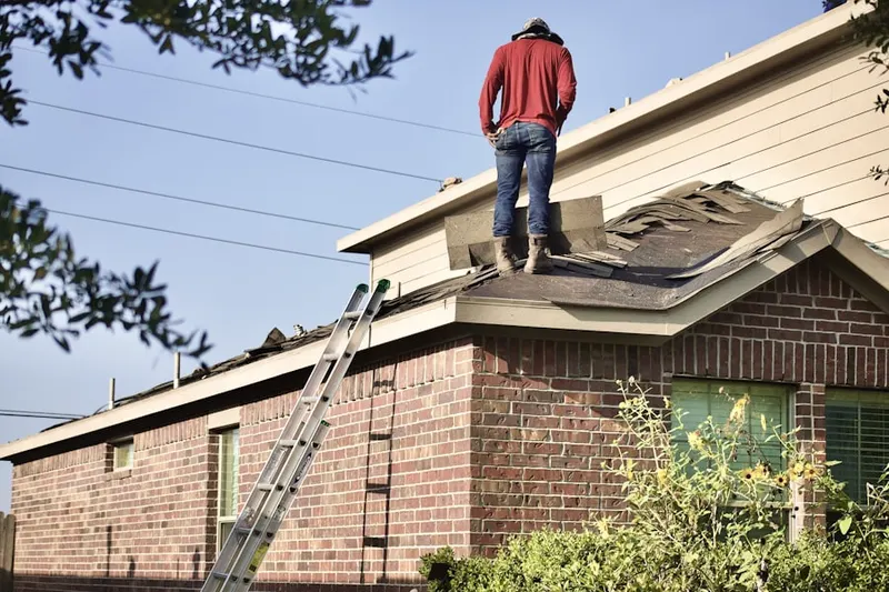 Professional roofer working on a residential roof in Saint Michael